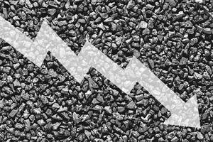 Arrow down on coal background. The concept of falling prices, mining, import, export, production or sales of coal. photo