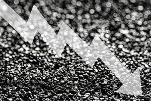 Arrow down on coal background. The concept of falling prices, mining, import, export, production or sales of coal. photo