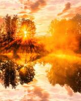 Sunrise on the pond in the autumn morning with birches and fog. photo