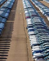 Rows of a new cars parked in a distribution center on a car factory on a sunny day. photo