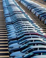 Rows of a new cars parked in a distribution center on a car factory on a sunny day. photo