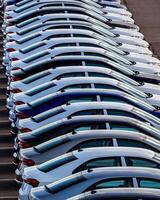 Rows of a new cars parked in a distribution center on a car factory on a sunny day. photo