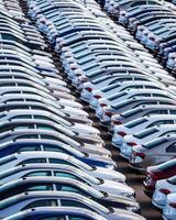 Rows of a new cars parked in a distribution center on a car factory on a sunny day. photo