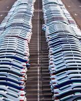 Rows of a new cars parked in a distribution center on a car factory on a sunny day. photo