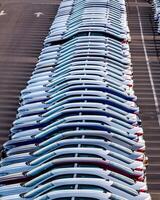 Rows of a new cars parked in a distribution center on a car factory on a sunny day. photo