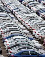Rows of a new cars parked in a distribution center of a car factory. photo