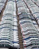 Rows of a new cars parked in a distribution center of a car factory. photo