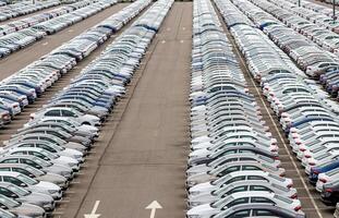 Rows of a new cars parked in a distribution center of a car factory. photo
