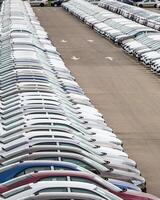 Rows of a new cars parked in a distribution center of a car factory. photo