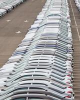 Rows of a new cars parked in a distribution center of a car factory. photo