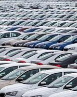 Rows of a new cars parked in a distribution center of a car factory. photo