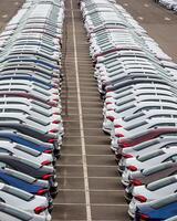 Rows of a new cars parked in a distribution center of a car factory. photo