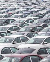 Rows of a new cars parked in a distribution center of a car factory. photo