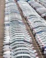 Rows of a new cars parked in a distribution center of a car factory. photo