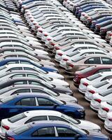 Rows of a new cars parked in a distribution center of a car factory. photo