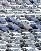 Rows of a new cars parked in a distribution center of a car factory. photo