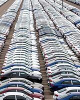 Rows of a new cars parked in a distribution center of a car factory. photo
