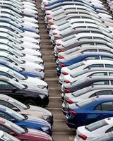 Rows of a new cars parked in a distribution center of a car factory. photo
