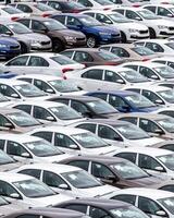 Rows of a new cars parked in a distribution center of a car factory. photo