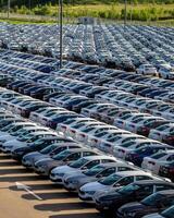 Volkswagen Group Rus, Russia, Kaluga - MAY 25, 2020 Rows of a new cars parked in a distribution center on a sunny day in the sprin. photo