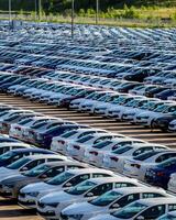 Volkswagen Group Rus, Russia, Kaluga - MAY 25, 2020 Rows of a new cars parked in a distribution center on a sunny day in the sprin. photo