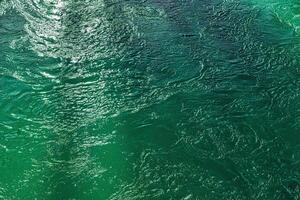 The texture of the waves of turquoise color of fast-flowing water in the river. photo