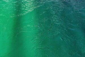 The texture of the waves of turquoise color of fast-flowing water in the river. photo