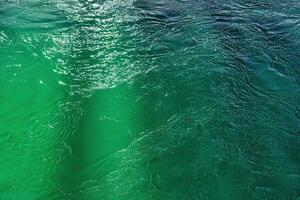 The texture of the waves of turquoise color of fast-flowing water in the river. photo