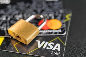 Russia, Kaluga - JULY 11, 2022 Debit or credit card with lock. The concept of security, protection or blocking of funds on the card. photo