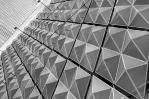Fragment of a modern building. Abstract geometric background. Part of the facade of a skyscraper with metal diamond-shaped grids. photo