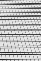Fragment of a modern office building. Abstract geometric background. Part of a skyscraper with glass windows. Black and white. photo