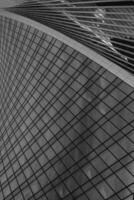 Fragment of a modern office building. Abstract geometric background. Part of a skyscraper with glass windows. Black and white. photo