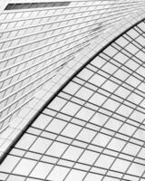 Fragment of a modern office building. Abstract geometric background. Part of a skyscraper with glass windows. Black and white. photo