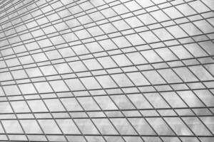 Fragment of a modern office building. Abstract geometric background. Part of a skyscraper with glass windows. Black and white. photo