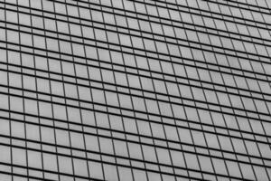 Fragment of a modern office building. Abstract geometric background. Part of a skyscraper with glass windows. Black and white. photo