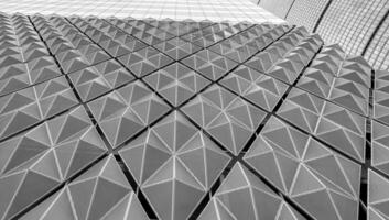 Fragment of a modern building. Abstract geometric background. Part of the facade of a skyscraper with metal diamond-shaped grids. photo
