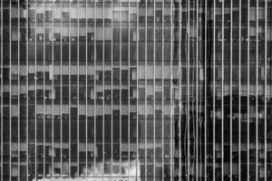Fragment of a modern office building. Abstract geometric background. Part of a skyscraper with glass windows. Black and white. photo