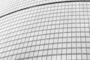 Fragment of a modern office building. Abstract geometric background. Part of a skyscraper with glass windows. Black and white. photo