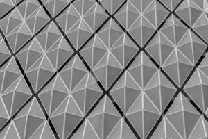 Fragment of a modern building. Abstract geometric background. Part of the facade of a skyscraper with metal diamond-shaped grids. photo