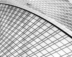 Fragment of a modern office building. Abstract geometric background. Part of a skyscraper with glass windows. Black and white. photo