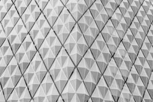 Fragment of a modern building. Abstract geometric background. Part of the facade of a skyscraper with metal diamond-shaped grids. photo