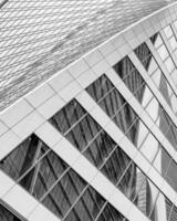 Fragment of a modern office building. Abstract geometric background. Part of a skyscraper with glass windows. Black and white. photo