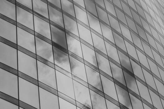 Fragment of a modern office building. Abstract geometric background. Part of a skyscraper with glass windows. Black and white. photo