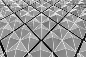 Fragment of a modern building. Abstract geometric background. Part of the facade of a skyscraper with metal diamond-shaped grids. photo