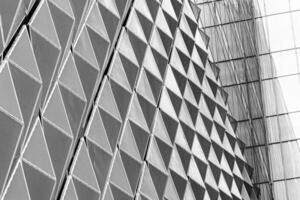 Fragment of a modern building. Abstract geometric background. Part of the facade of a skyscraper with metal diamond-shaped grids. photo