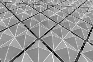 Fragment of a modern building. Abstract geometric background. Part of the facade of a skyscraper with metal diamond-shaped grids. photo