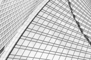 Fragment of a modern office building. Abstract geometric background. Part of a skyscraper with glass windows. Black and white. photo