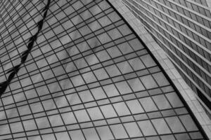 Fragment of a modern office building. Abstract geometric background. Part of a skyscraper with glass windows. Black and white. photo