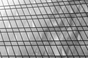 Fragment of a modern office building. Abstract geometric background. Part of a skyscraper with glass windows. Black and white. photo