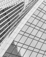Fragment of a modern office building. Abstract geometric background. Part of a skyscraper with glass windows. Black and white. photo